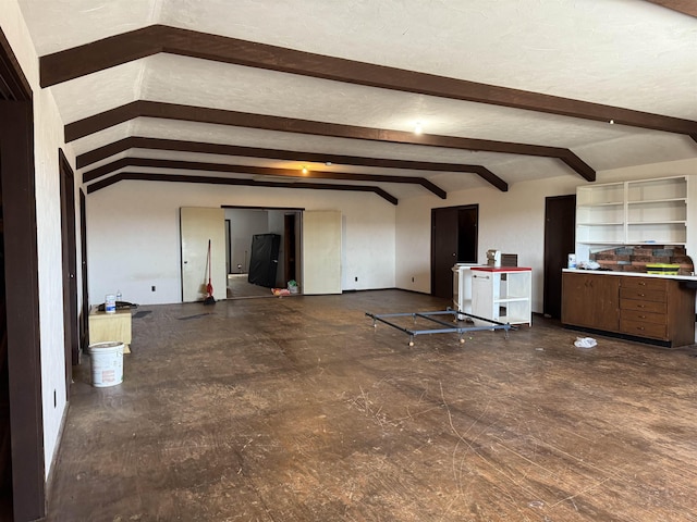 unfurnished living room featuring a textured ceiling and lofted ceiling with beams