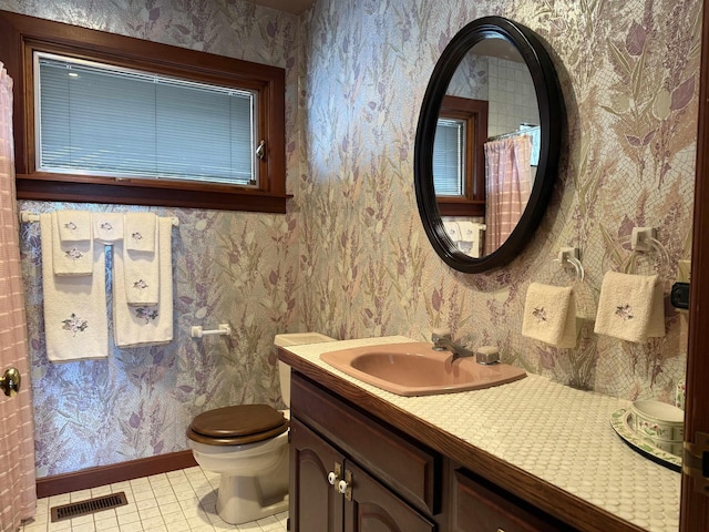 bathroom with visible vents and wallpapered walls