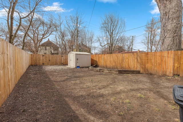 view of yard featuring a storage unit, a fenced backyard, and an outdoor structure