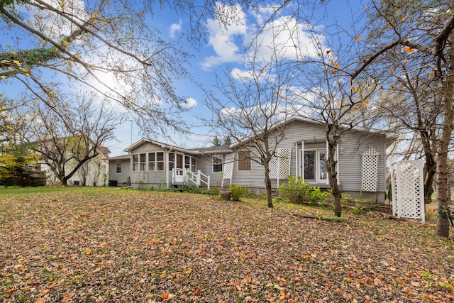 rear view of property featuring a sunroom and crawl space