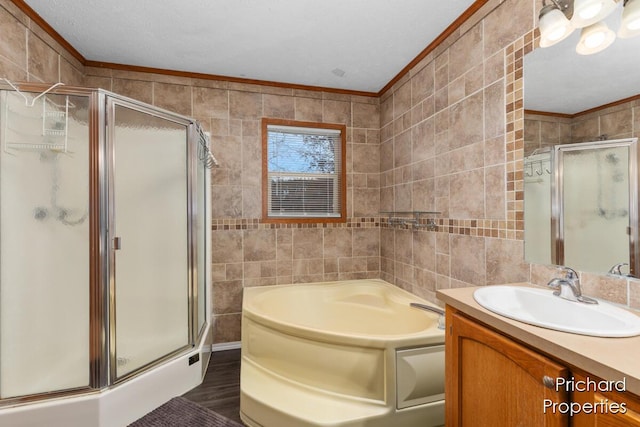 bathroom featuring a shower stall, tile walls, and crown molding