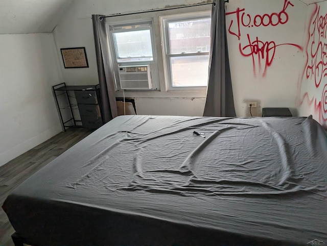 bedroom with vaulted ceiling, cooling unit, wood finished floors, and baseboards
