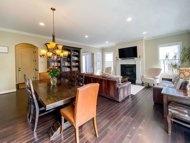 220 S Castell Ave, Rochester, MI 48307 - dining area with a chandelier, arched walkways, dark wood-style flooring, ornamental molding, and a glass covered fireplace