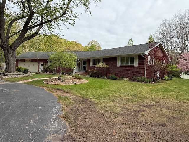 7298 W M-116, Ludington, MI 49431 - single story home featuring brick siding, an attached garage, a front yard, asphalt driveway, and a shingled roof