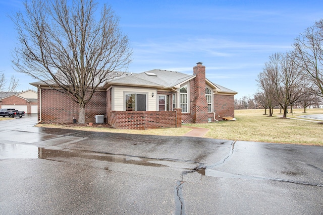50128 Bethesda, Shelby Twp, MI 48317 - view of front of property with brick siding, a chimney, cooling unit, and a front yard