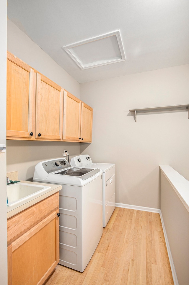 50128 Bethesda, Shelby Twp, MI 48317 - clothes washing area featuring attic access, light wood-style flooring, baseboards, washer and dryer, and cabinet space