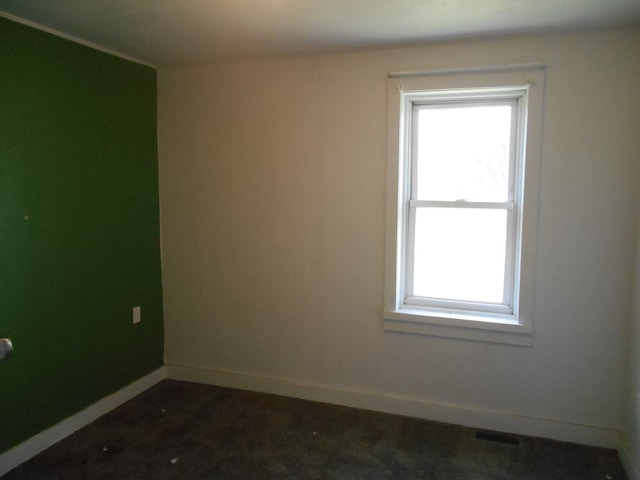 5972 Birch Run Rd, Millington, MI 48746 - spare room with baseboards, dark carpet, and visible vents