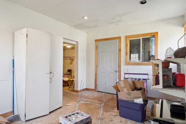 interior space with baseboards and unfinished concrete floors