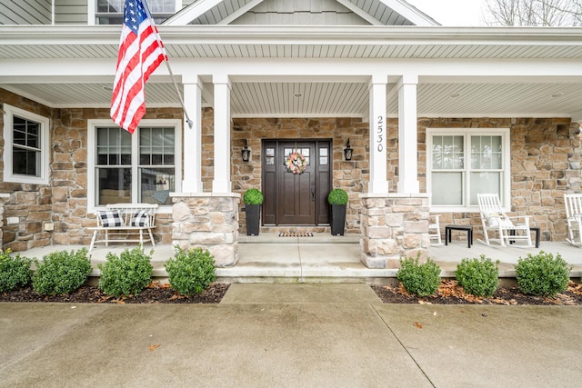 property entrance with stone siding and covered porch