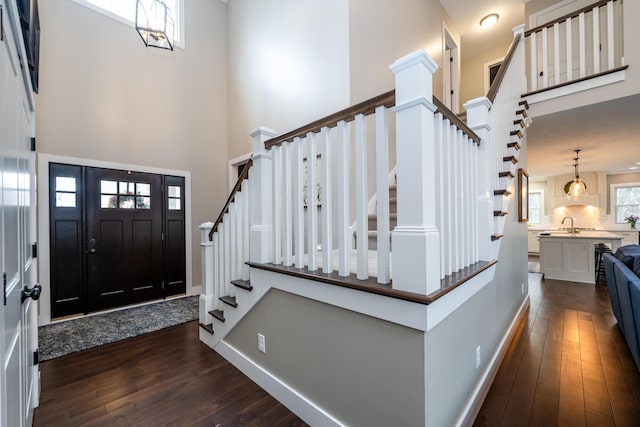 foyer featuring stairway, a high ceiling, dark wood-style floors, and baseboards