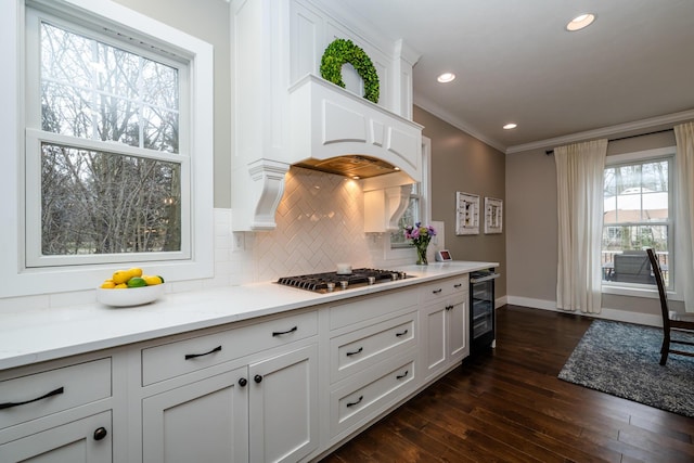 kitchen with ornamental molding, wine cooler, stainless steel gas stovetop, decorative backsplash, and dark wood-style flooring