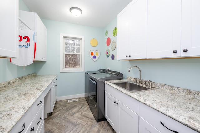 laundry room with visible vents, independent washer and dryer, a sink, cabinet space, and baseboards