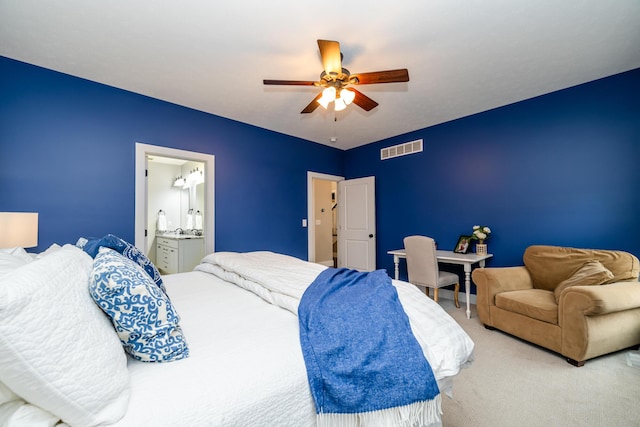 carpeted bedroom featuring visible vents, ensuite bath, and a ceiling fan