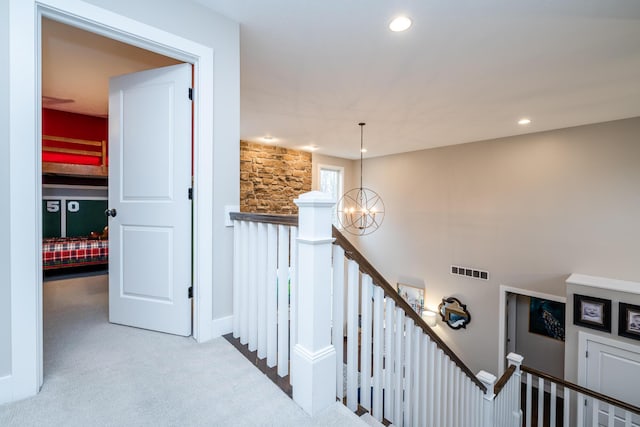 corridor with visible vents, carpet floors, an inviting chandelier, recessed lighting, and an upstairs landing