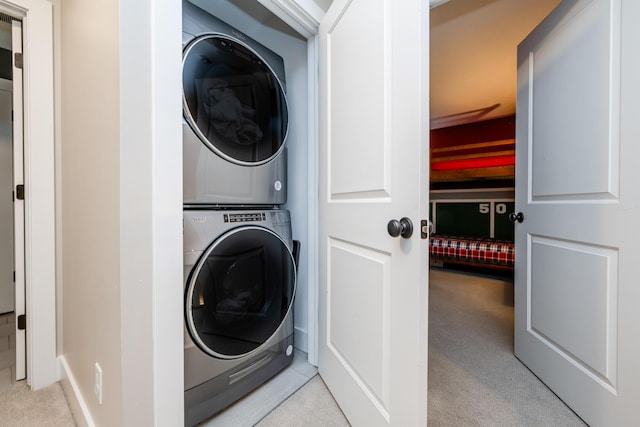 washroom with stacked washer / drying machine, carpet flooring, and laundry area