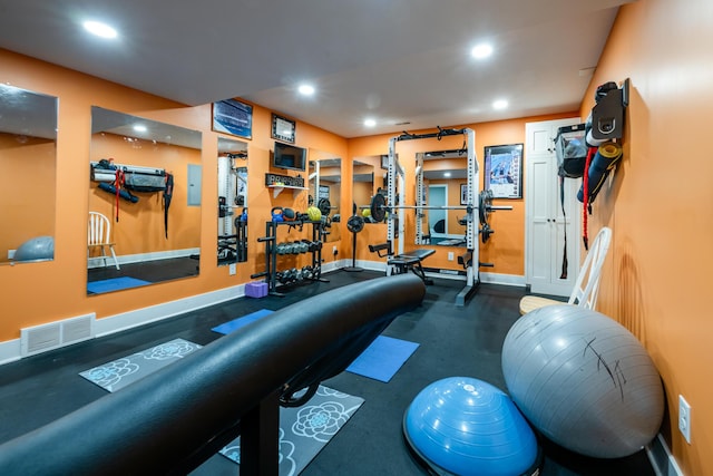 workout area with recessed lighting, visible vents, baseboards, and electric panel
