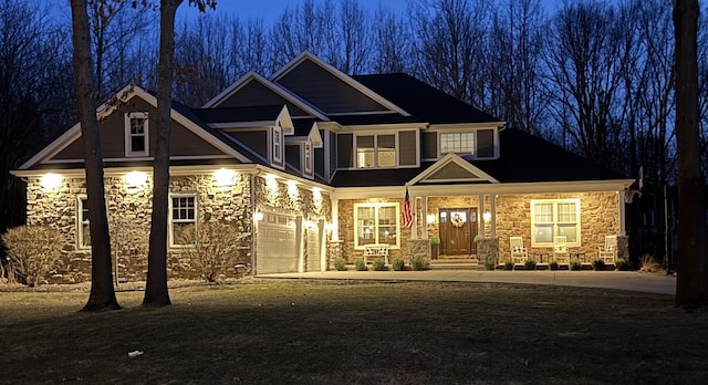 craftsman-style home featuring a garage, stone siding, covered porch, and concrete driveway
