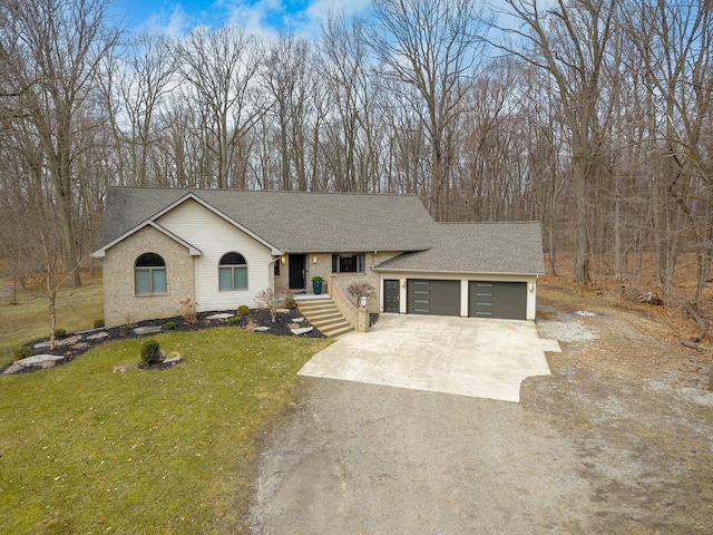 ranch-style home with concrete driveway, a shingled roof, a garage, and a front lawn