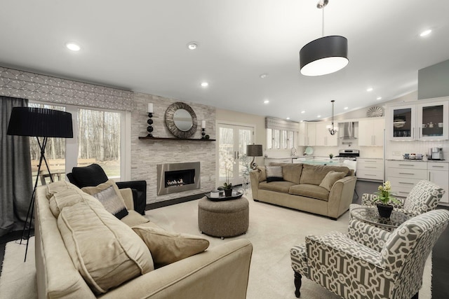 living room with lofted ceiling, a fireplace, recessed lighting, and light colored carpet