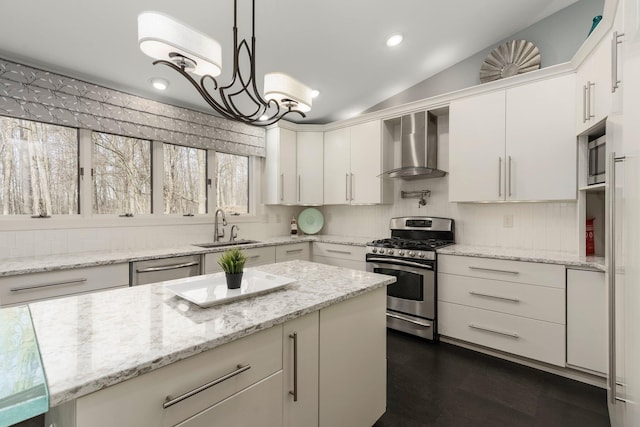 kitchen with a sink, stainless steel appliances, tasteful backsplash, wall chimney exhaust hood, and vaulted ceiling