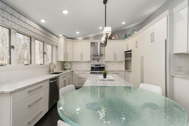 kitchen with a sink, stainless steel appliances, tasteful backsplash, wall chimney range hood, and recessed lighting