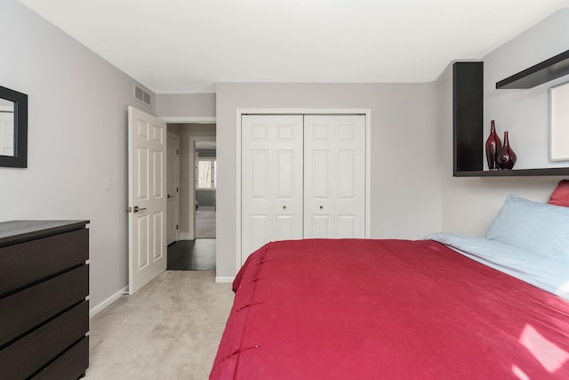 bedroom with baseboards, a closet, visible vents, and light colored carpet