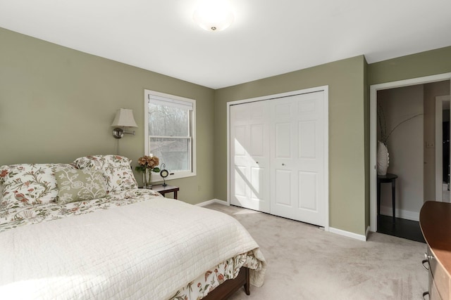 bedroom with baseboards, light carpet, and a closet
