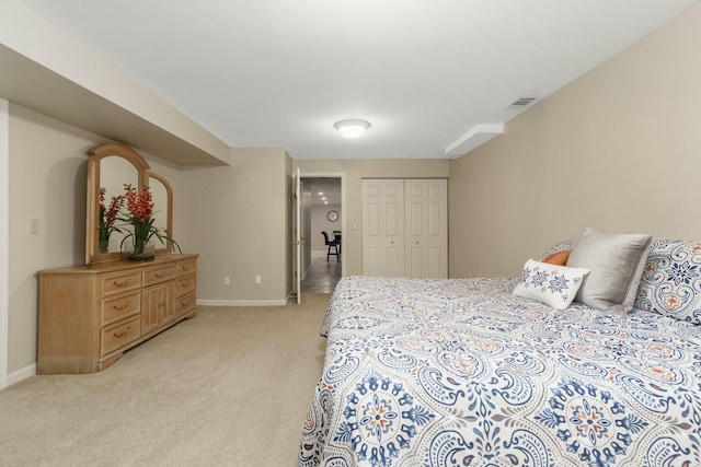 bedroom with baseboards, a closet, visible vents, and light colored carpet