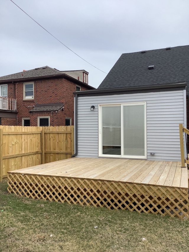 back of property featuring a deck and fence