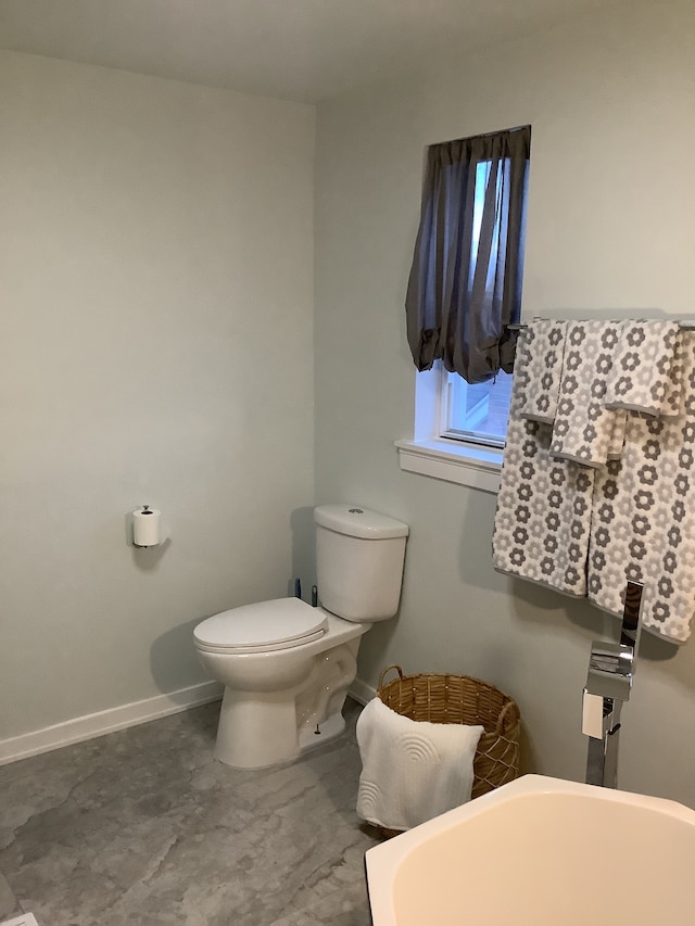 bathroom with toilet and baseboards