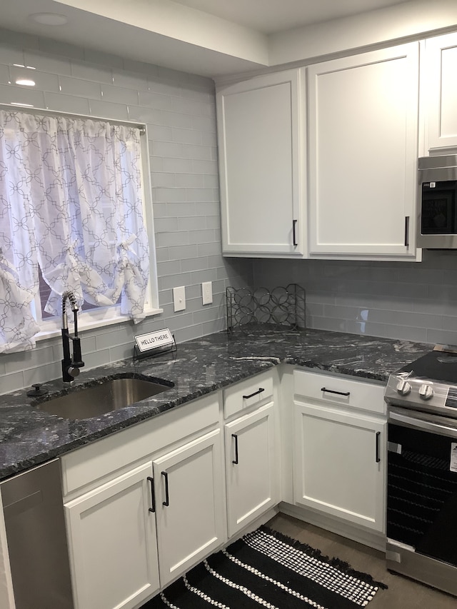 kitchen featuring decorative backsplash, appliances with stainless steel finishes, and a sink
