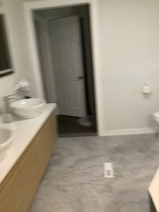 bathroom featuring toilet and double vanity