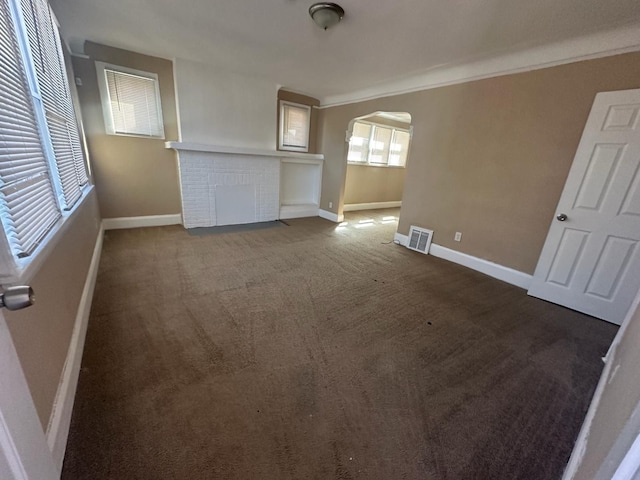 19980 Hickory St, Detroit, MI 48205 - unfurnished living room featuring arched walkways, carpet, and a fireplace