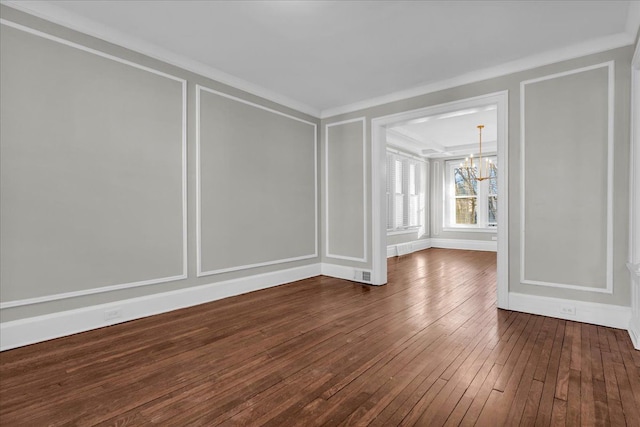 spare room with visible vents, crown molding, a decorative wall, a chandelier, and dark wood-style flooring