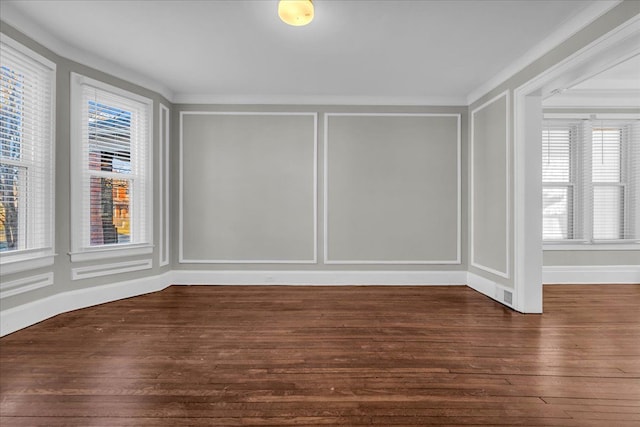 spare room featuring a decorative wall and wood finished floors