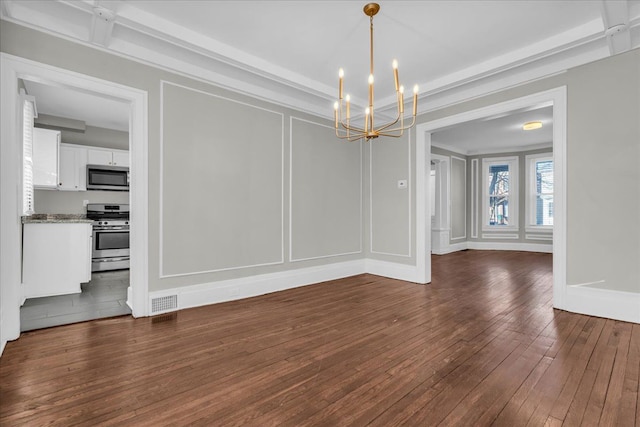 unfurnished dining area featuring dark wood-type flooring, a decorative wall, visible vents, and a chandelier