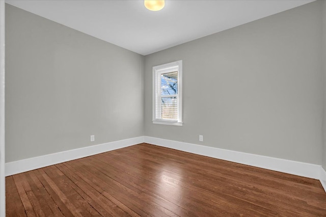 empty room with baseboards and dark wood-style flooring