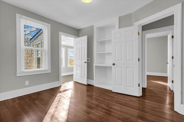 unfurnished bedroom featuring dark wood-type flooring and baseboards