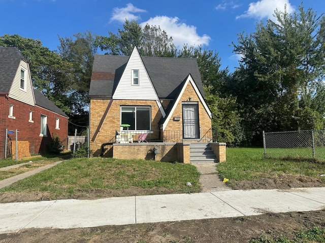 view of front of property with covered porch, brick siding, and fence
