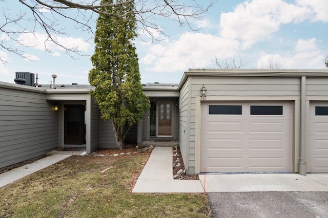 view of front of home featuring central AC, a garage, and driveway