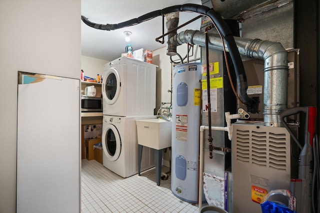 laundry area featuring water heater, laundry area, and stacked washer and dryer
