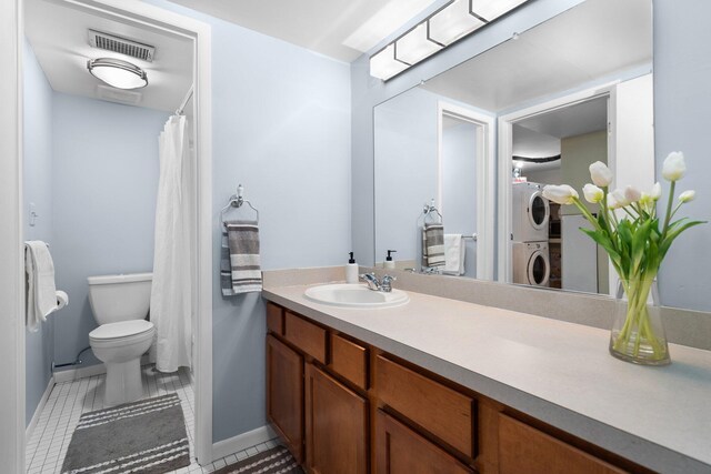 bathroom with vanity, visible vents, tile patterned flooring, stacked washer / dryer, and toilet
