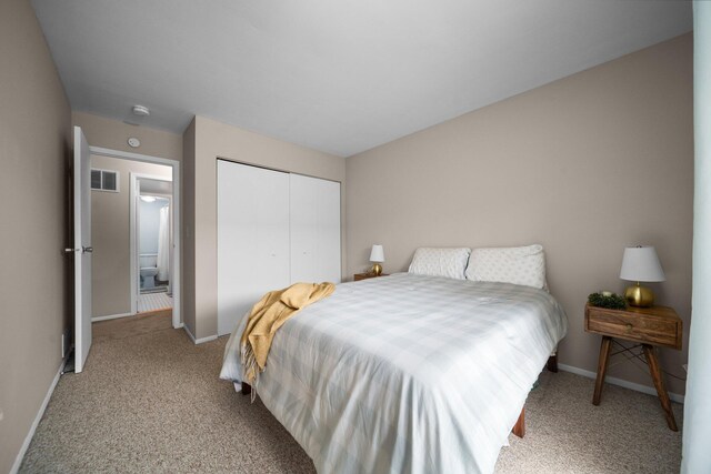 bedroom featuring light colored carpet, visible vents, a closet, and baseboards