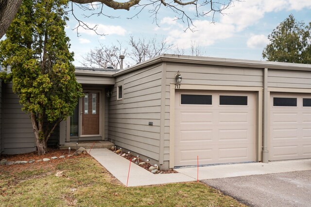 view of front of property with aphalt driveway and a garage