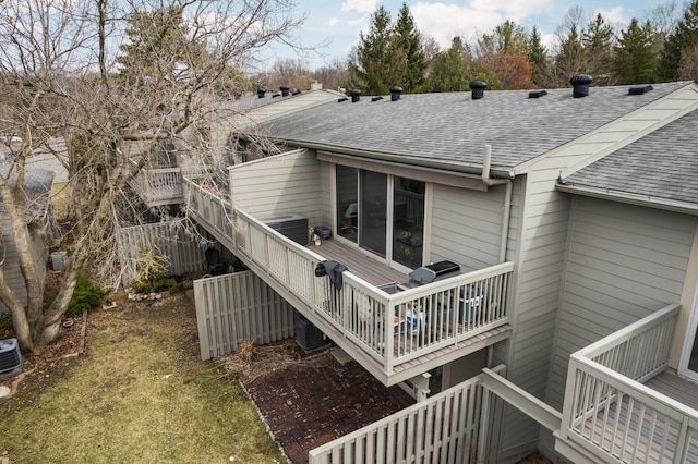 back of property featuring a wooden deck, cooling unit, a shingled roof, and stairs