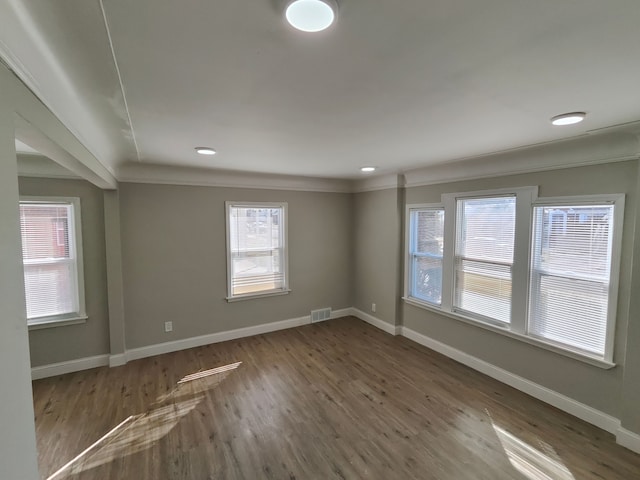 spare room with wood finished floors, baseboards, and ornamental molding