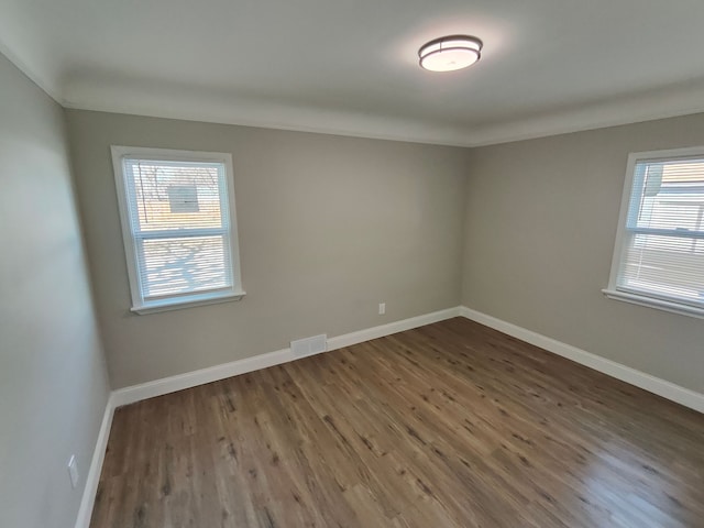 empty room with dark wood finished floors and baseboards