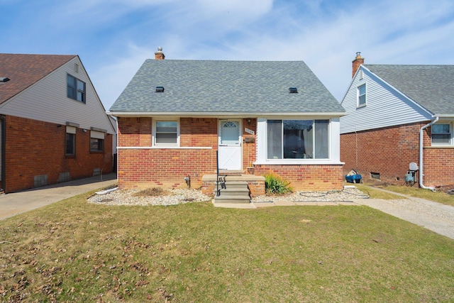 view of front of property with a chimney, a front lawn, brick siding, and a shingled roof
