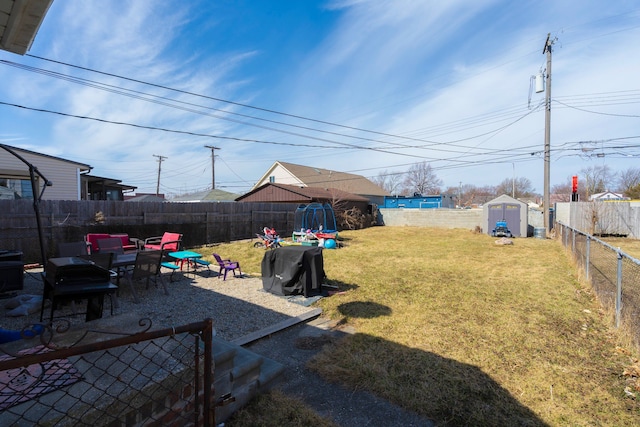 view of yard featuring a fenced backyard, an outdoor structure, and a shed