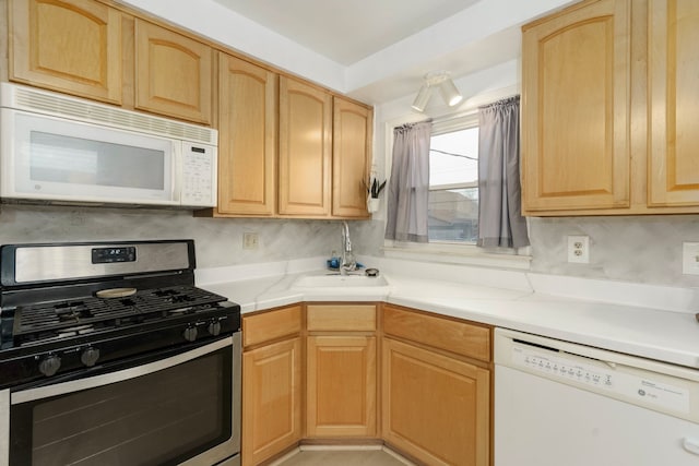 kitchen featuring light brown cabinetry and white appliances